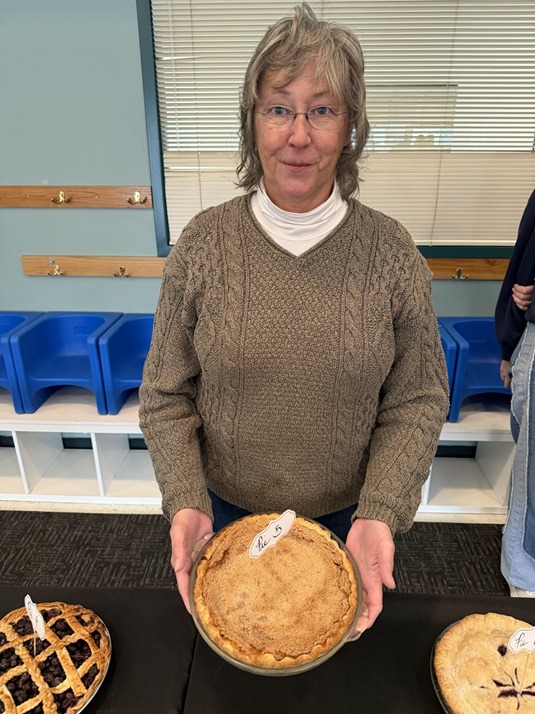 A pie baking contestant holding her pie